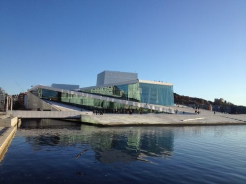 Bildet er et eksempel på et sparetips for ting å gjøre som er gratis og viser Den Norske Opera & Ballett huset i Oslo med sjøen foran og blå klar himmel i bakgrunnen.