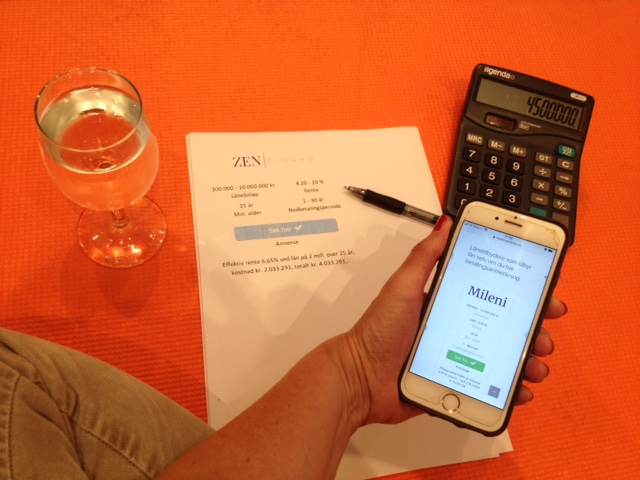 Kvinne som sitter på en orange yogamatte med utskrift fra Zen Finans, kalkulator og et glass kaldt vann mens hun holder på med mobilen sin og sjekker refinansiering hos Mileni på Låneoversikten